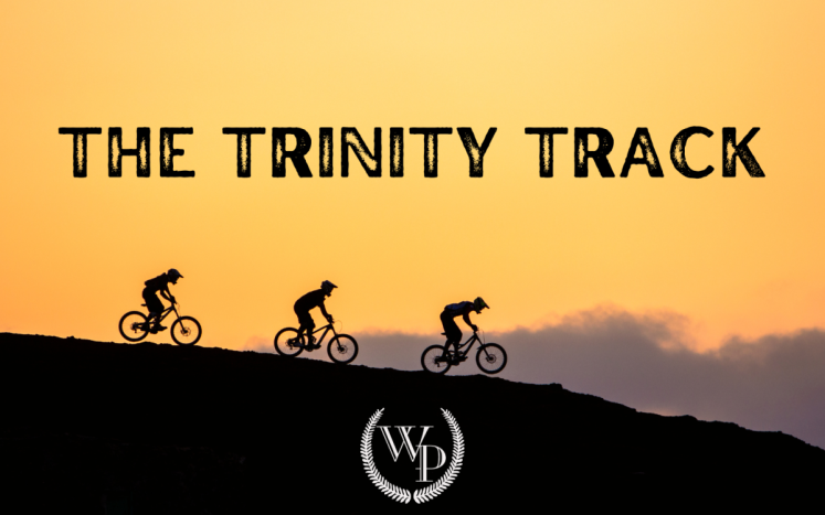 Photo of mountain bikers with the text "The Trinity Track"